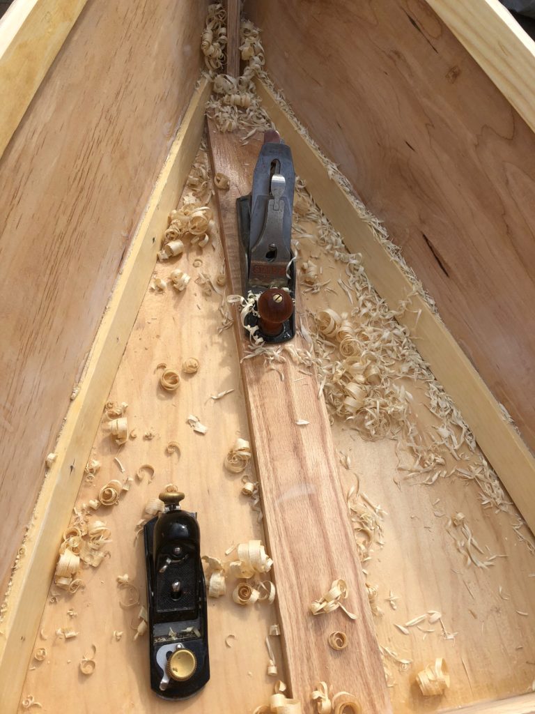 Shavings collect in the hull from planing the wood.